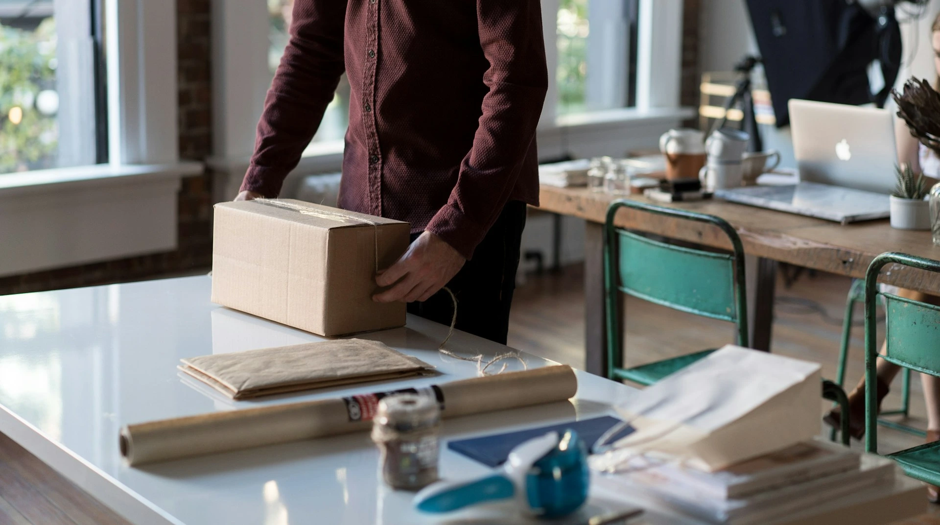 person holding cardboard box on table
